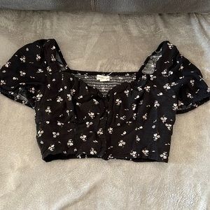 Black crop off the shoulder top with white flower design. Size small